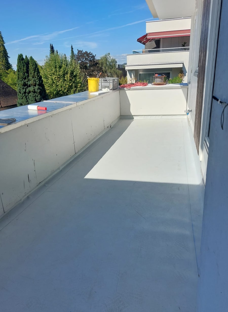Abgedichteter Balkon mit umlaufender Attika – modernes Finish, funktional geschützt.