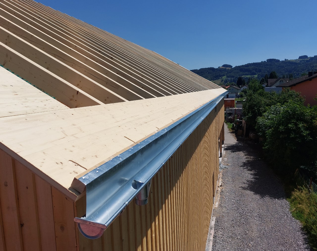 Zink-Dachrinne und Traufverblechung im Neubau – exakt angepasst an die Holzkonstruktion. Saubere Linienführung und funktionale Eleganz in klassischer Ausführung.