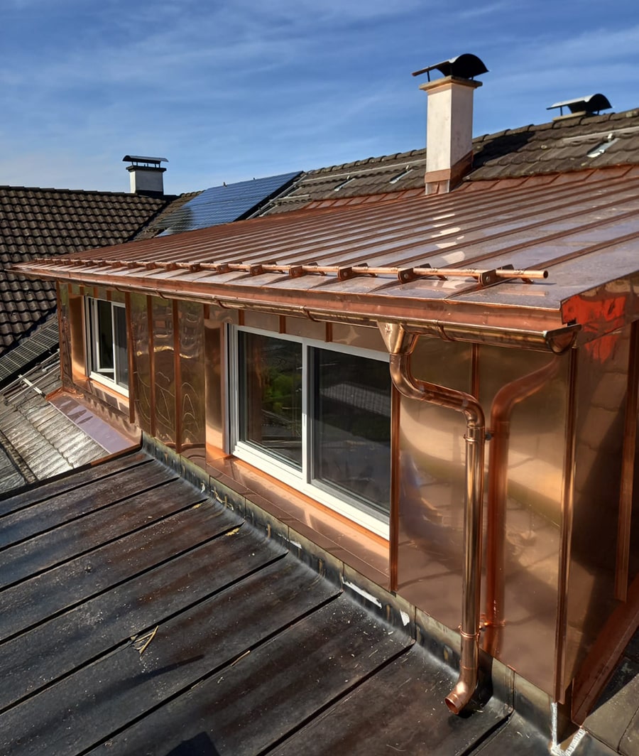 Gaupe in handwerklich gearbeiteter Kupferverkleidung – langlebig, wetterfest und architektonisch harmonisch ins Dach integriert.